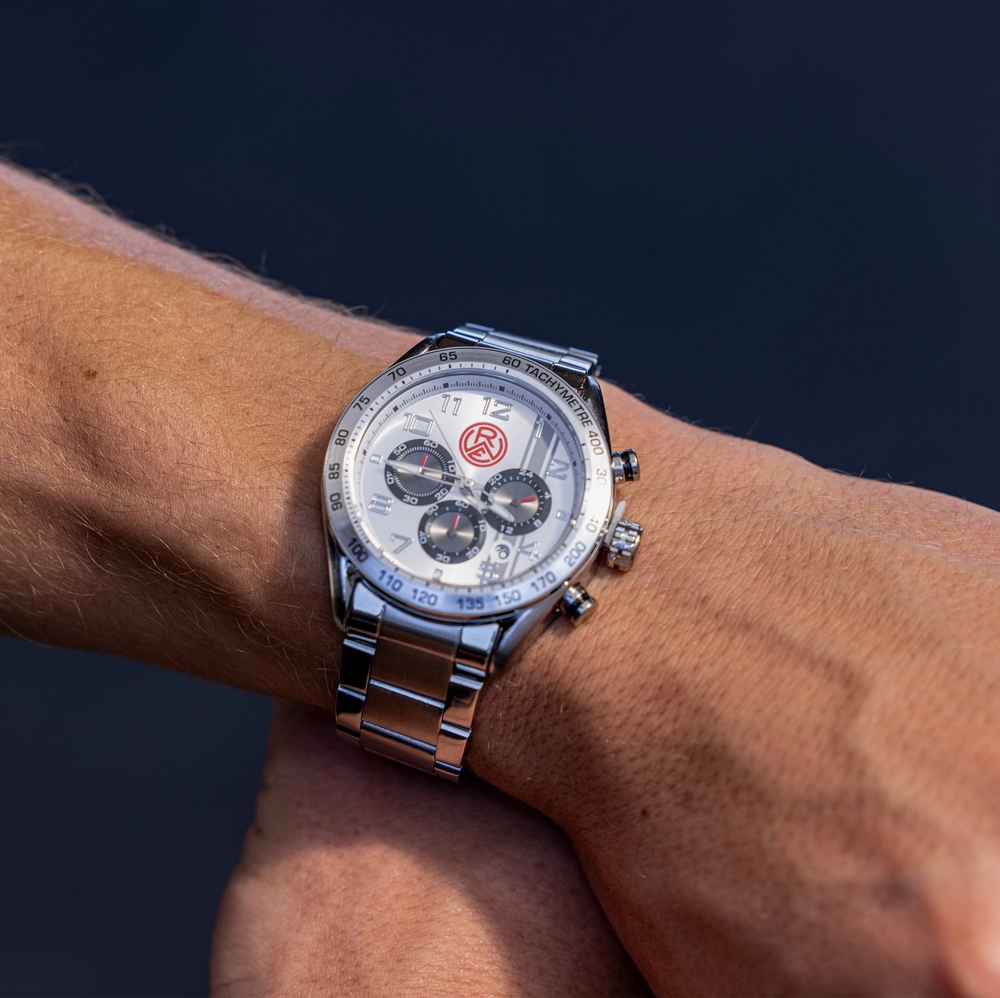 Sportlicher Herrenchronograph in silber: 44mm mit Tachymetertopring, Stoppfunktionund Datumanzeige | Effektzifferblatt mit Logoaufdruck stoßfeste Mineralglaslinse | 3 ATM Wasserdicht | solides Edelstahlarmband mit Sicherheitsfaltschließe z.T. gebürstet | Edelstahluhrenboden
Model Tom Moustier