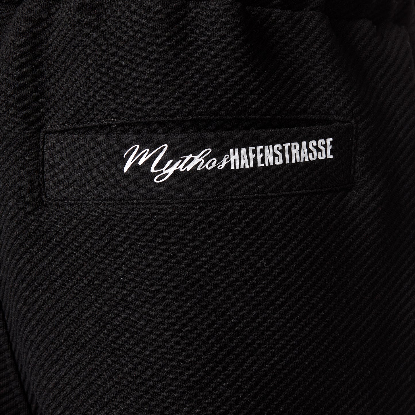 Nahaufnahme Style 2559 Hose "Mythos" Druck, "Mythos" vorne in kursiver Schrift, danach "HAFENSTRASSE" in RWE-Blockschrift, beides aneinandergereiht