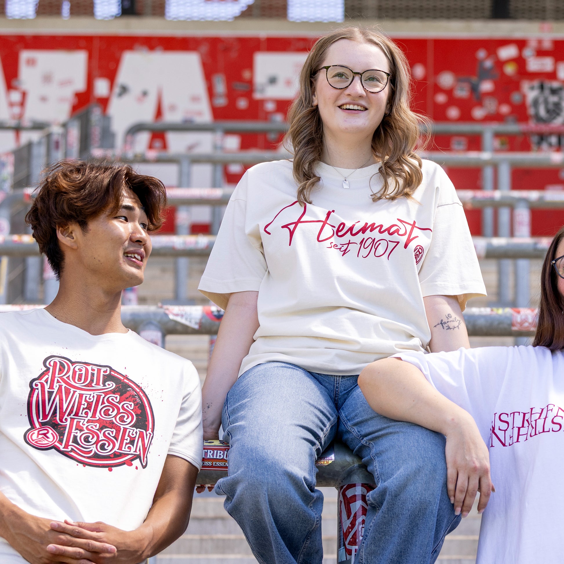 Marie trägt cremefarbenes Oversize T-Shirt mit einem roten "Heimat seit 1907"-Druck mittig auf der Brust, inkl. Rot-Weiss Essen Logo