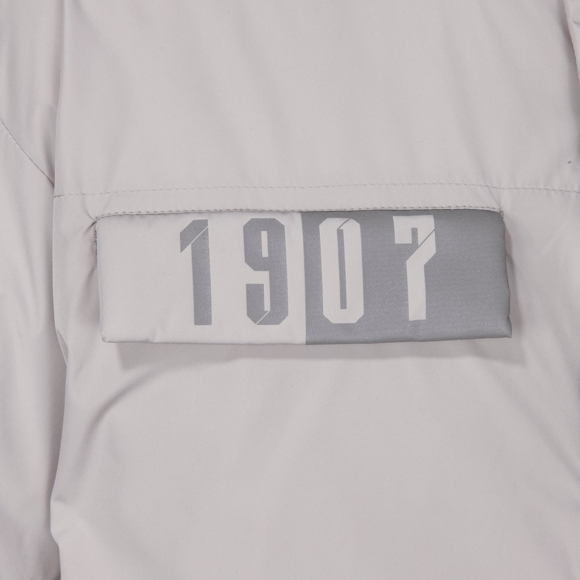Nahaufnahme reflektierender "1907" Druck auf rechter Brusttasche, silber/grau