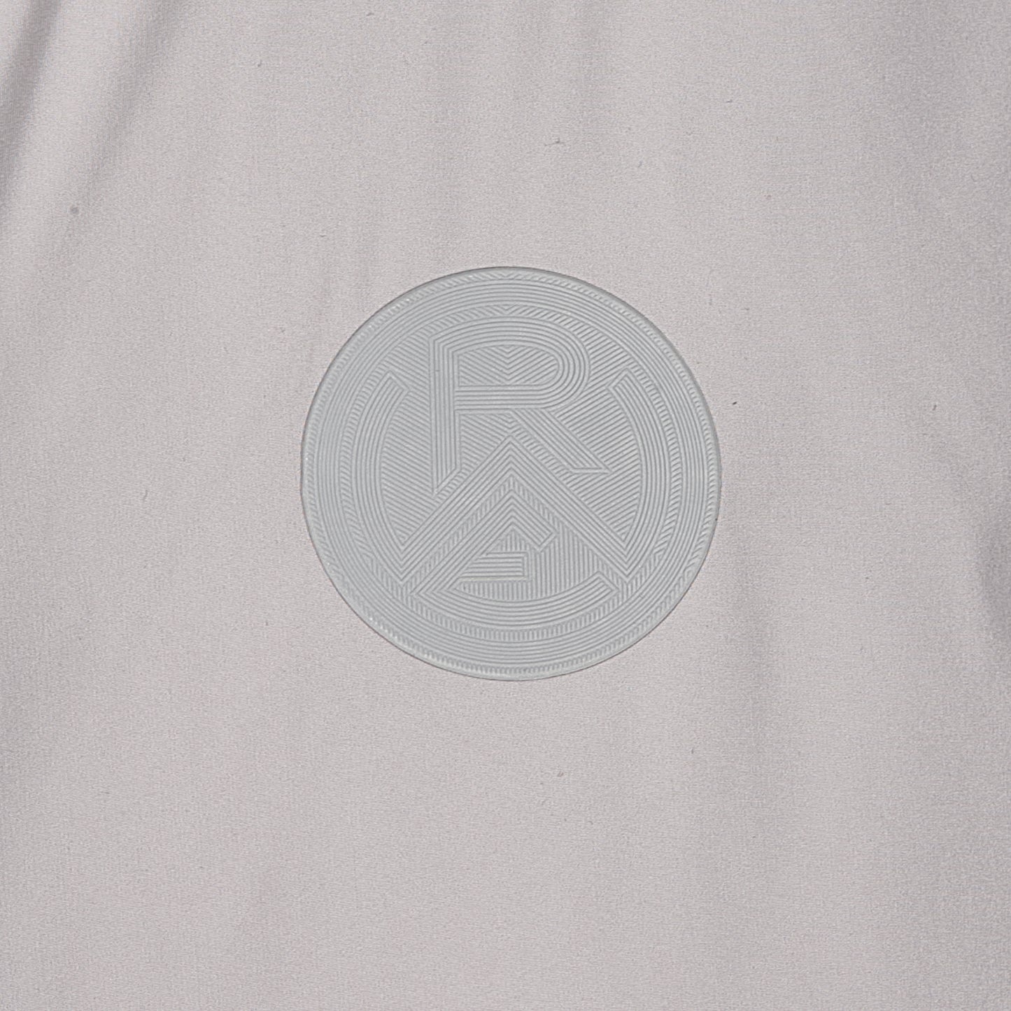 Nahaufnahme RWE-Logo Silikonpatch, Ton-in-Ton zur hellgrauen Jacke