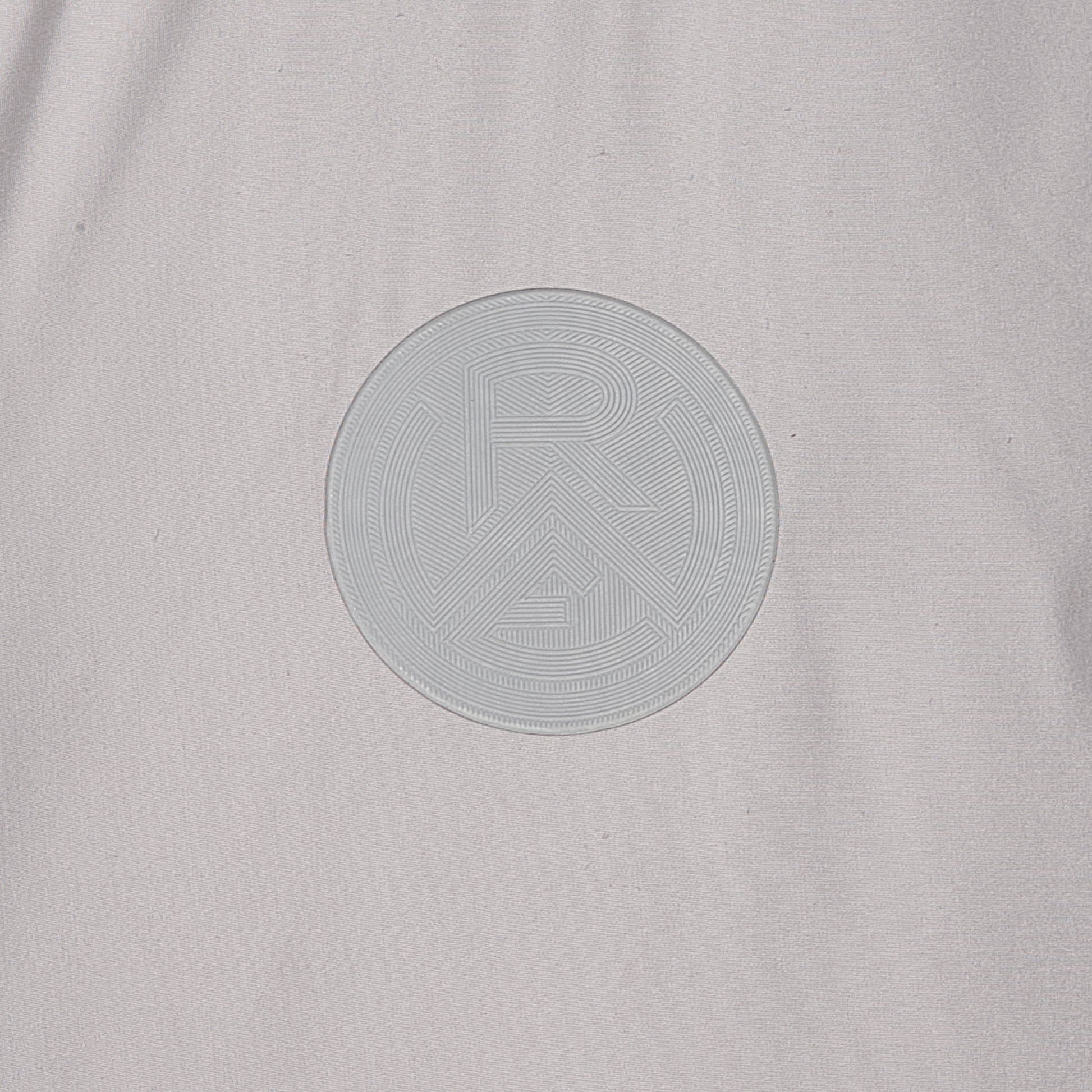 Nahaufnahme RWE-Logo Silikonpatch, Ton-in-Ton zur hellgrauen Jacke
